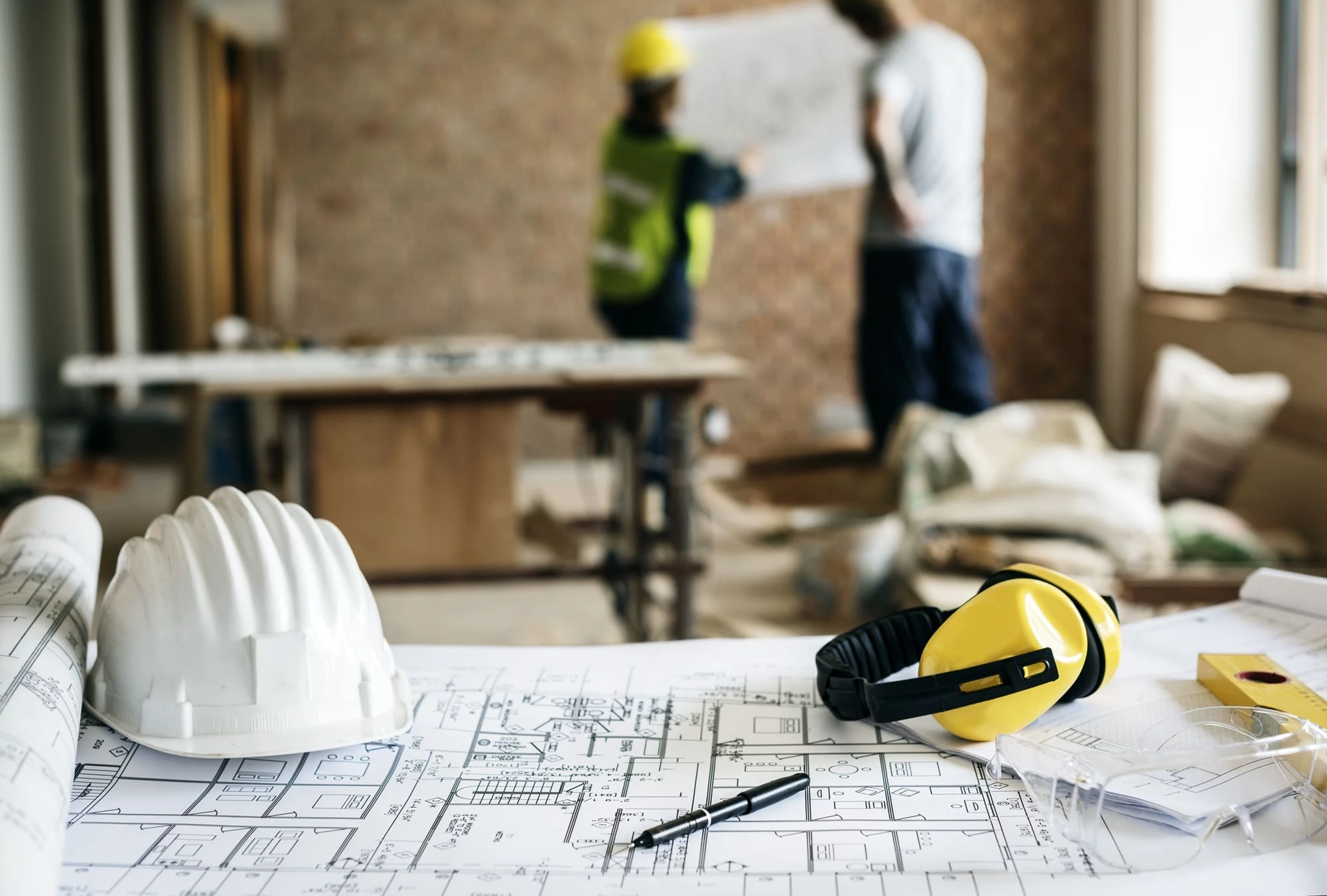 Planos arquitectónicos con obra en remodelación al fondo.